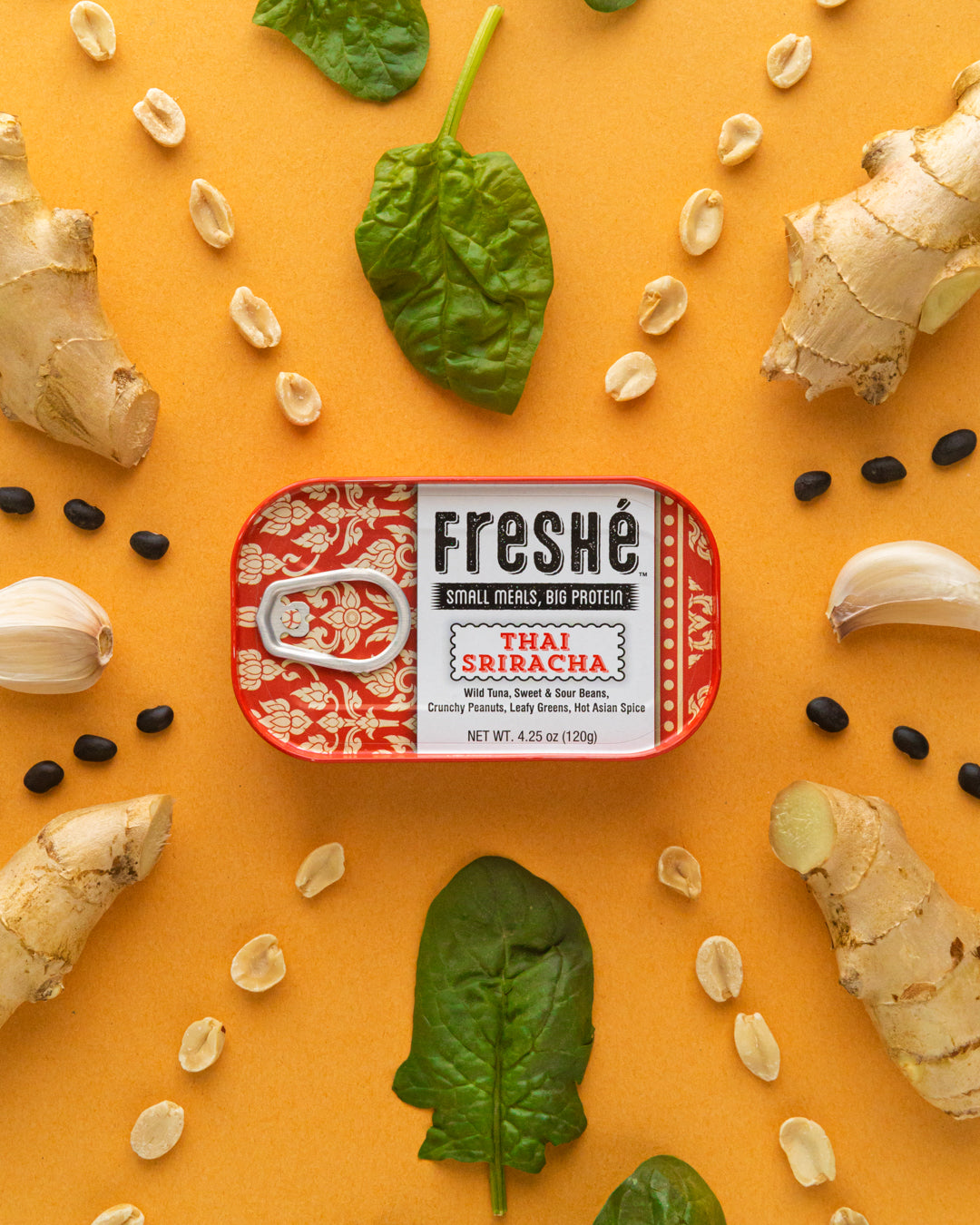 Freshé Thai Sriracha tuna tin surrounded by fresh ginger, garlic, spinach and peanuts